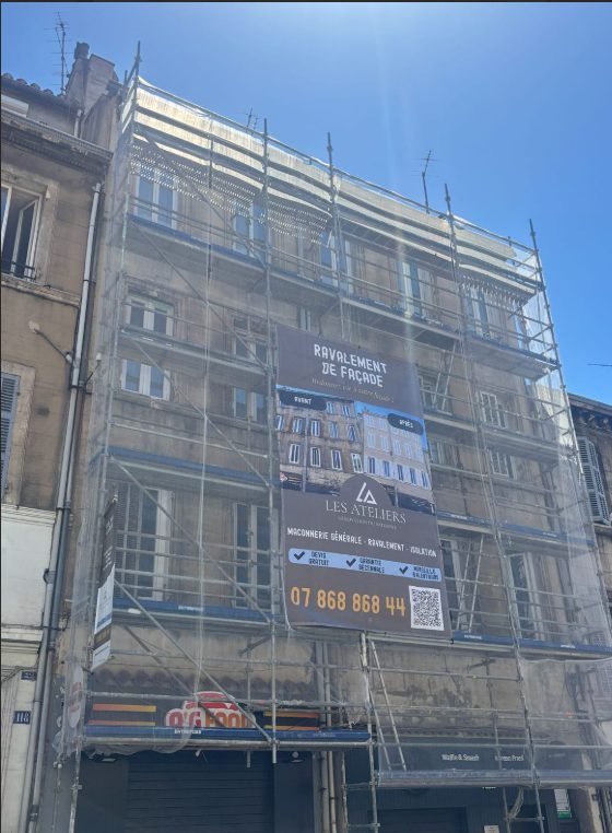 Échafaudage et bâche Les Ateliers sur un chantier de ravalement de façade à Marseille